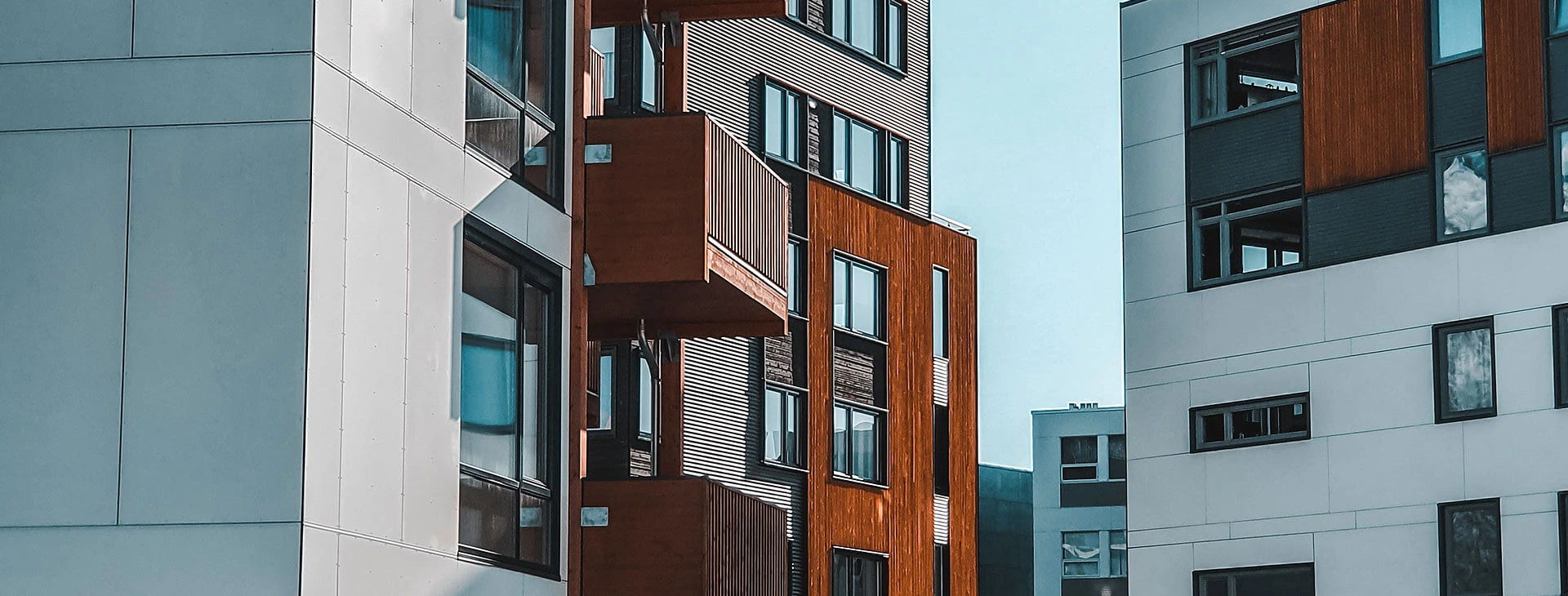 Modern apartment buildings with white and brown exteriors, multiple windows, and balconies, situated close together under a clear blue sky—perfect for those seeking quality living with expert commercial property management in Brantford.