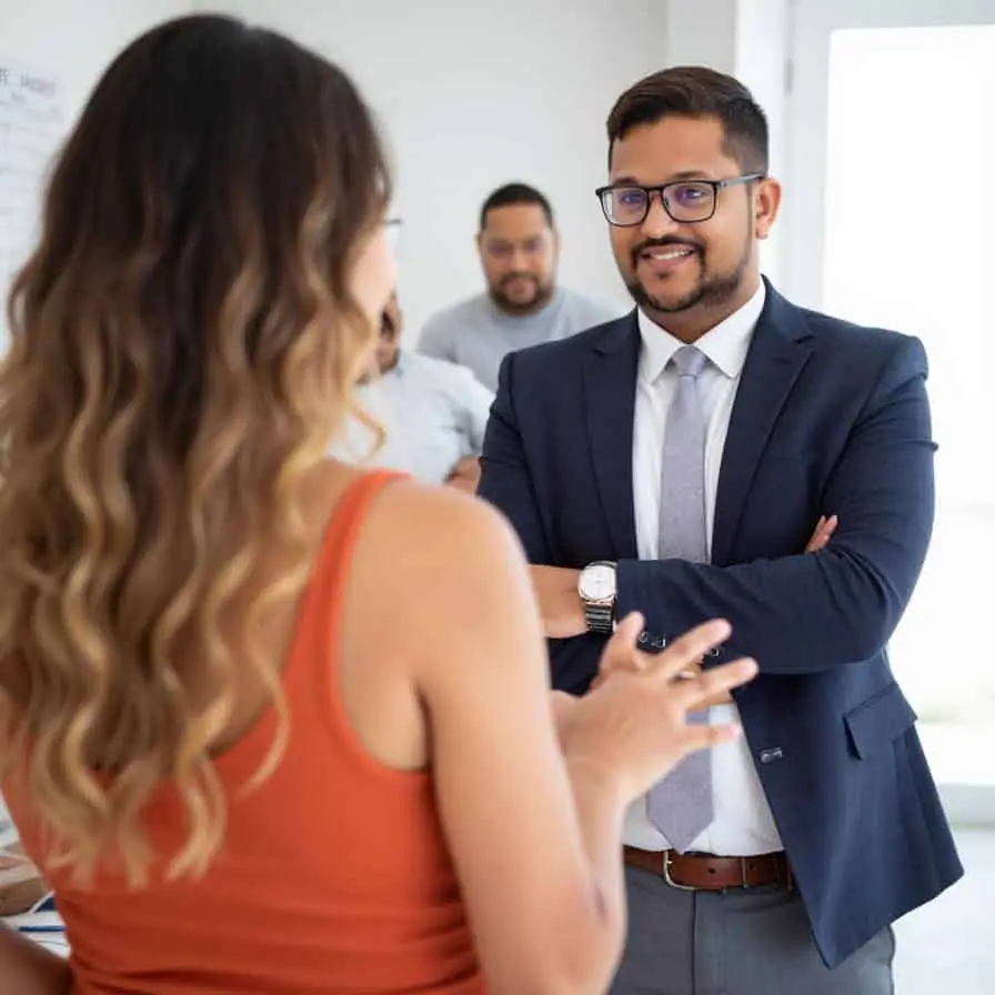 a man in a suit and a woman in a room with other people